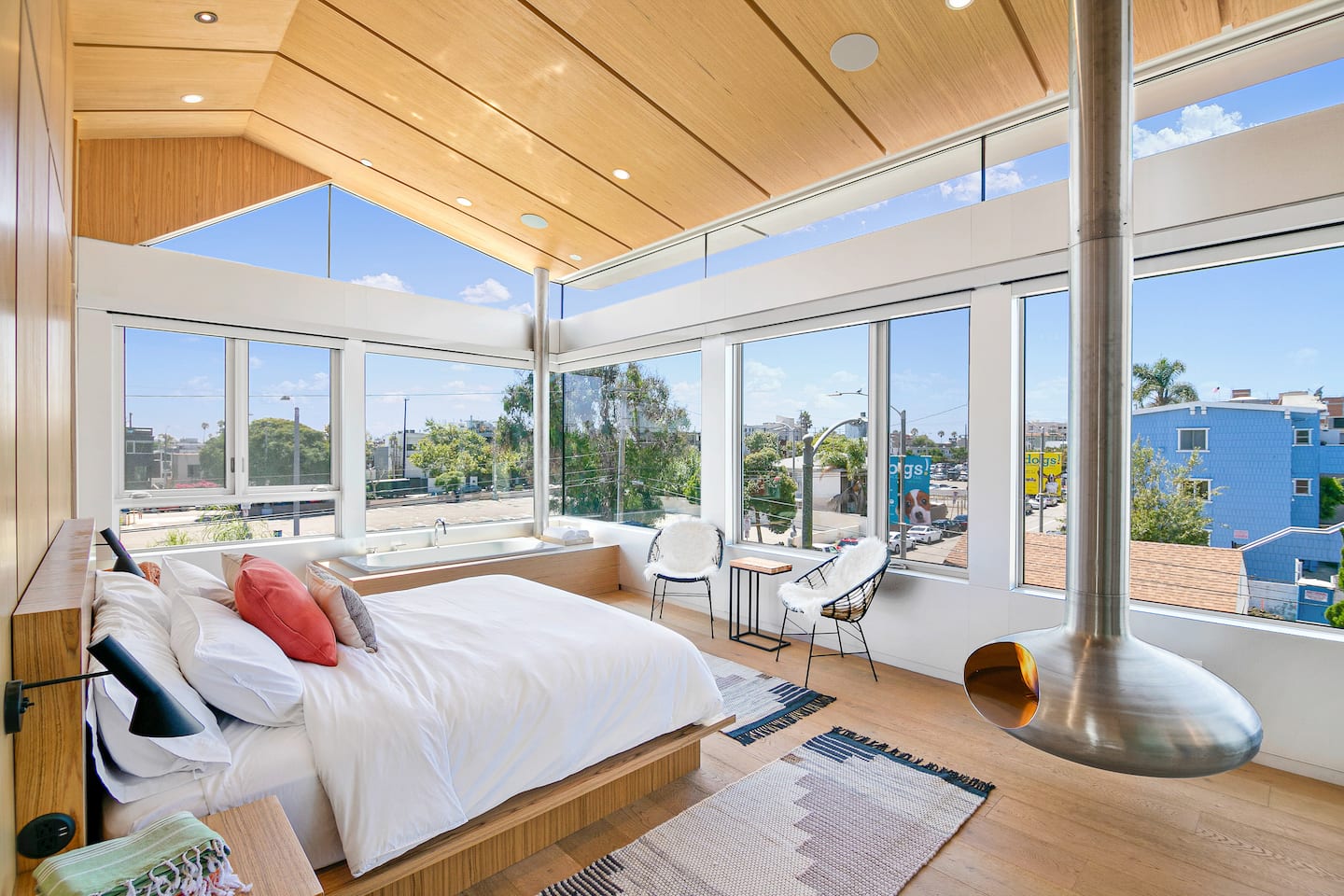 Master bedroom with bathtub, fire orb, and panoramic views. Automatic shades provide privacy.
